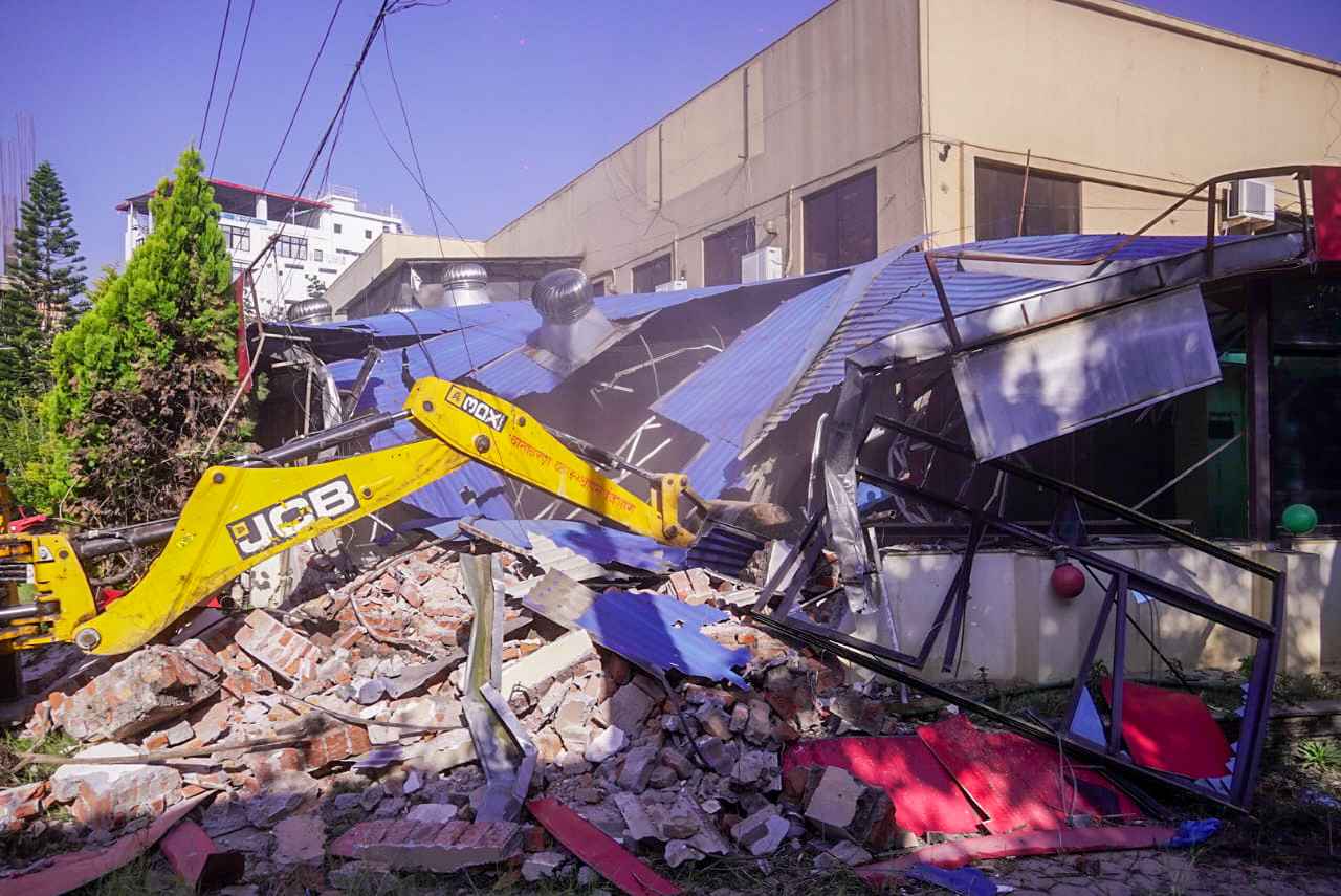 स्काउट जग्गा प्रकरणः भाडा नतिरेपछि दीपक खड्काको कम्पनीमा महानगरको डोजर, सबै संरचना भत्काइए (तस्बिरहरूसहित)